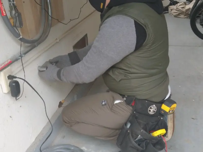 Electrician performing outlet wiring in a Roma garage
